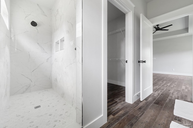 bathroom featuring ceiling fan, tiled shower, and hardwood / wood-style floors