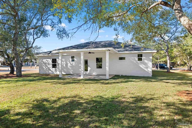 rear view of property with a lawn, ceiling fan, and a patio