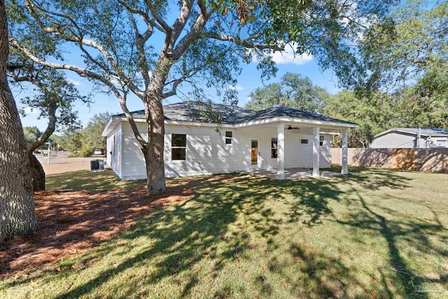 rear view of house with a lawn and a patio