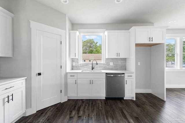 kitchen with dark hardwood / wood-style flooring, dishwasher, white cabinets, and sink