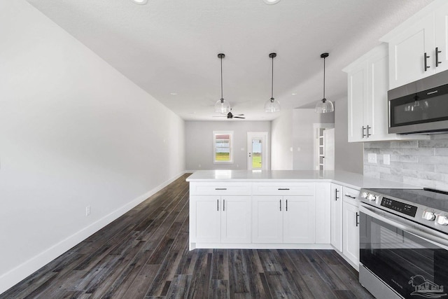 kitchen featuring decorative light fixtures, kitchen peninsula, decorative backsplash, appliances with stainless steel finishes, and white cabinets