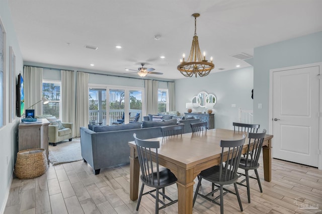 dining space featuring light wood-type flooring, ceiling fan with notable chandelier, visible vents, and recessed lighting