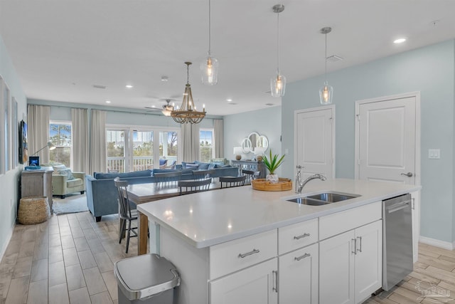 kitchen with dishwasher, open floor plan, a sink, and a wealth of natural light