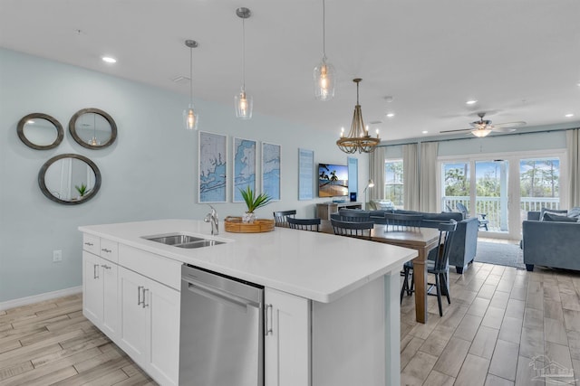 kitchen featuring dishwasher, open floor plan, wood tiled floor, a kitchen island with sink, and a sink