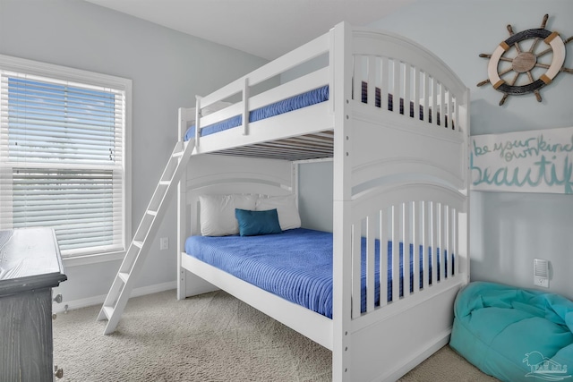 carpeted bedroom featuring multiple windows and baseboards