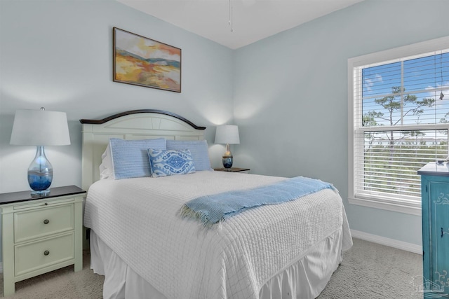 bedroom with light carpet and baseboards