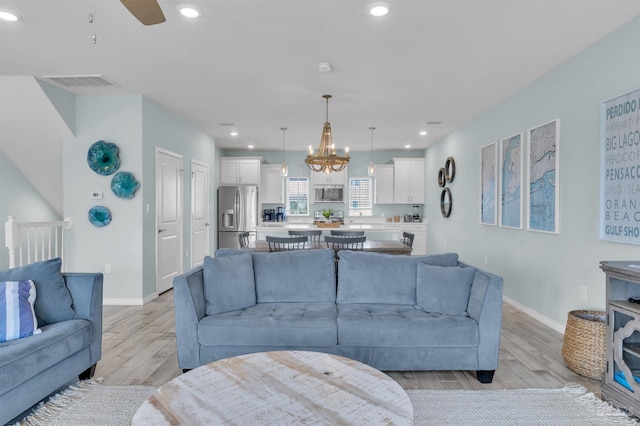 living room featuring light wood-type flooring, baseboards, visible vents, and recessed lighting