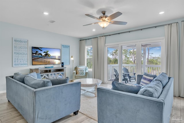 living room featuring light wood-style flooring, visible vents, and recessed lighting