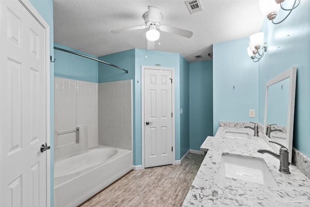 2759 Pleasant Bay Ct, Navarre, FL 32566 - bathroom with  shower combination, wood finished floors, a ceiling fan, a textured ceiling, and double vanity