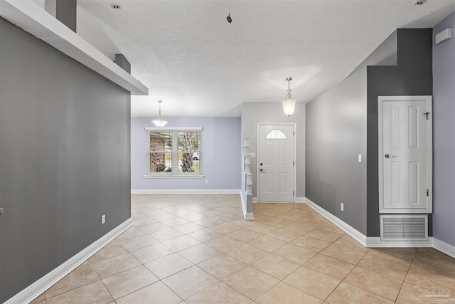 2759 Pleasant Bay Ct, Navarre, FL 32566 - entryway featuring light tile patterned floors, a textured ceiling, baseboards, and lofted ceiling