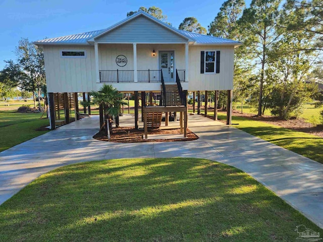 view of front facade featuring a porch, a front yard, and a carport