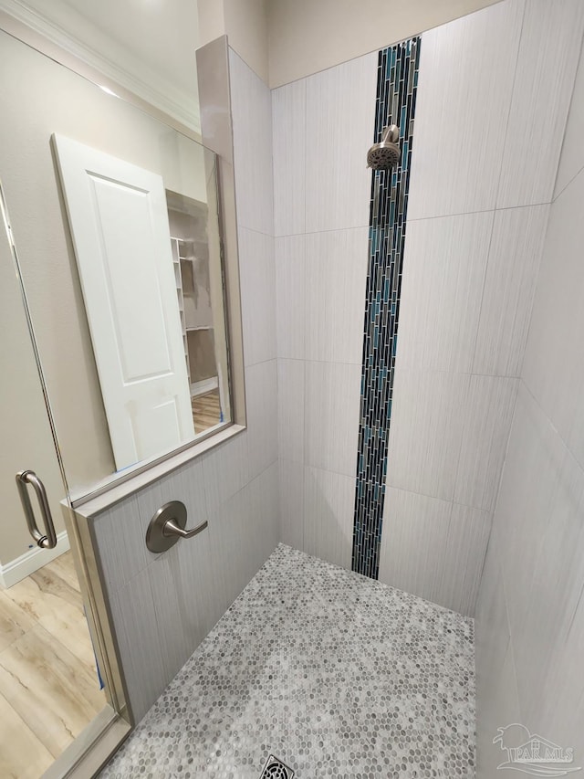 bathroom featuring hardwood / wood-style flooring and a tile shower