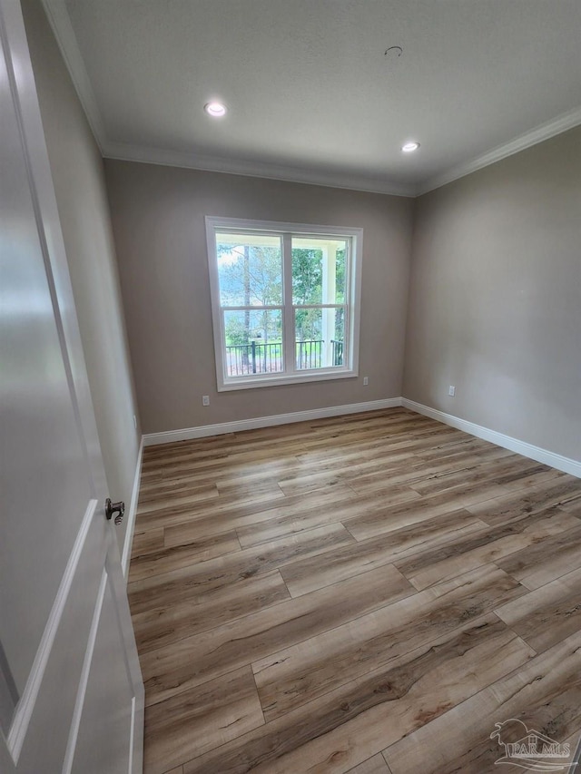 unfurnished room with light hardwood / wood-style floors and crown molding