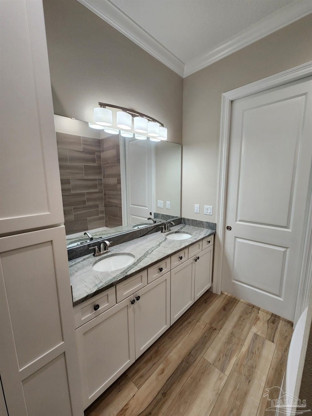 bathroom with wood-type flooring, vanity, and ornamental molding