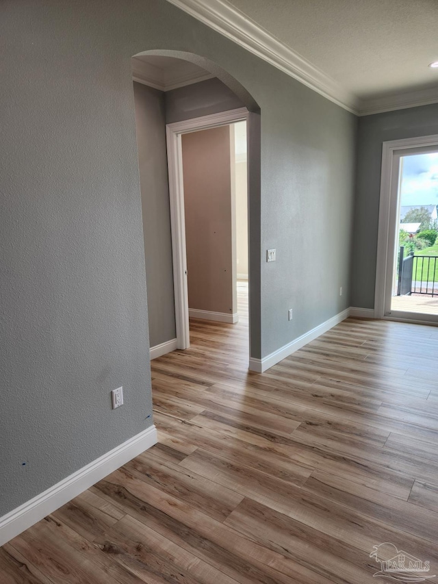 spare room with light hardwood / wood-style floors and crown molding