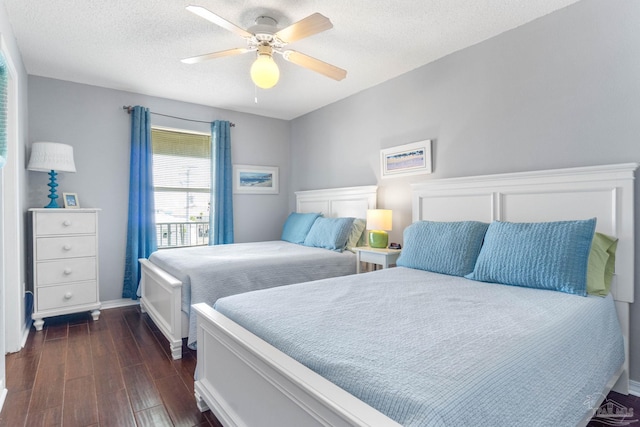 bedroom featuring a textured ceiling, ceiling fan, and dark hardwood / wood-style flooring