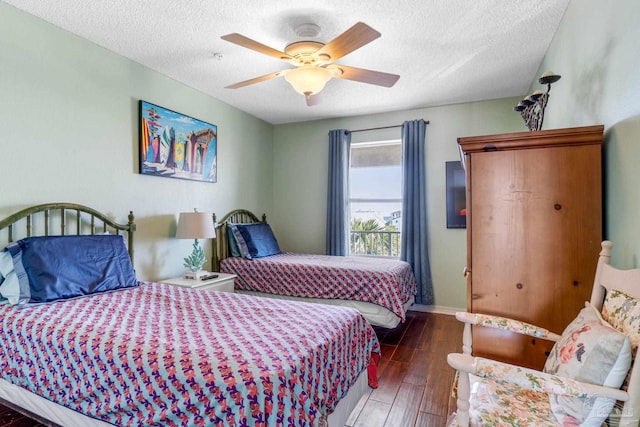 bedroom with dark hardwood / wood-style floors, a textured ceiling, and ceiling fan