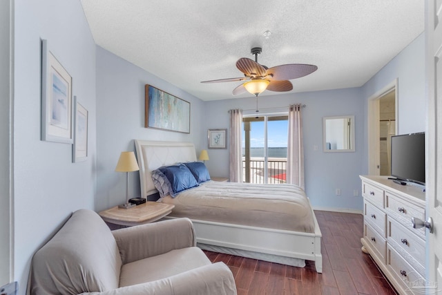 bedroom with dark wood-type flooring, a textured ceiling, and ceiling fan