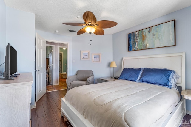 bedroom with dark hardwood / wood-style floors, a textured ceiling, and ceiling fan