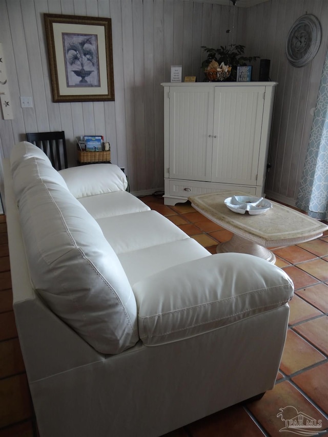 living room featuring tile patterned flooring and wooden walls