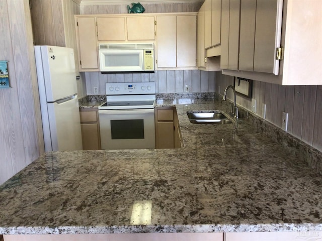 kitchen featuring white appliances, sink, kitchen peninsula, and stone countertops