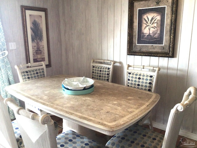 dining area featuring wooden walls