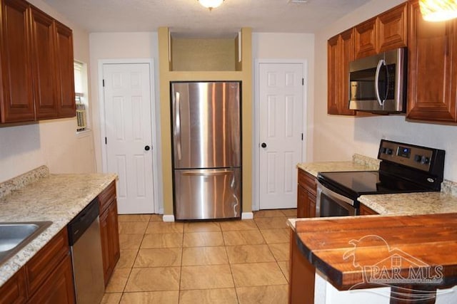 kitchen with light tile patterned floors and stainless steel appliances