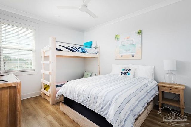 bedroom featuring wood-type flooring, crown molding, and ceiling fan