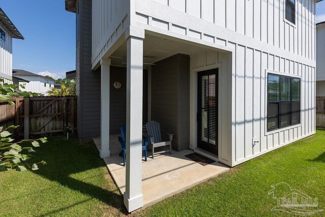 doorway to property with a lawn and a patio area