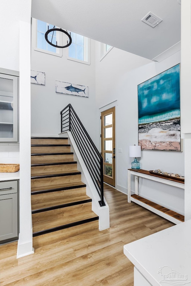 stairs with a high ceiling and hardwood / wood-style flooring