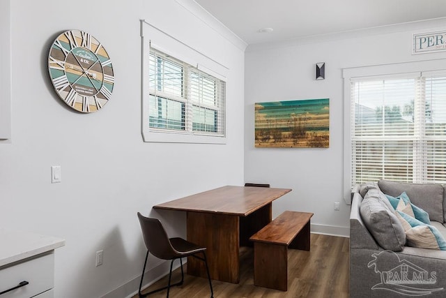 dining room with dark hardwood / wood-style floors, ornamental molding, and a wealth of natural light