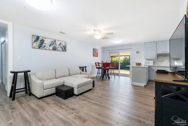 living room featuring light wood-type flooring and ceiling fan