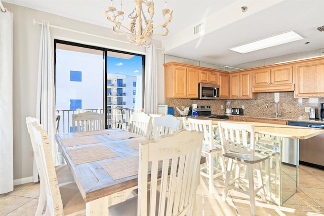 tiled dining area featuring sink and an inviting chandelier