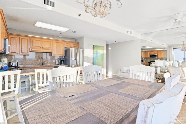 tiled dining room with sink and a notable chandelier