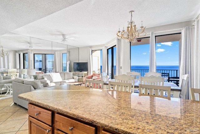 kitchen featuring a textured ceiling, light tile patterned floors, and ceiling fan with notable chandelier