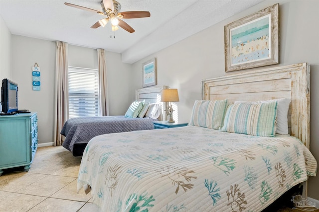 tiled bedroom with ceiling fan and a textured ceiling