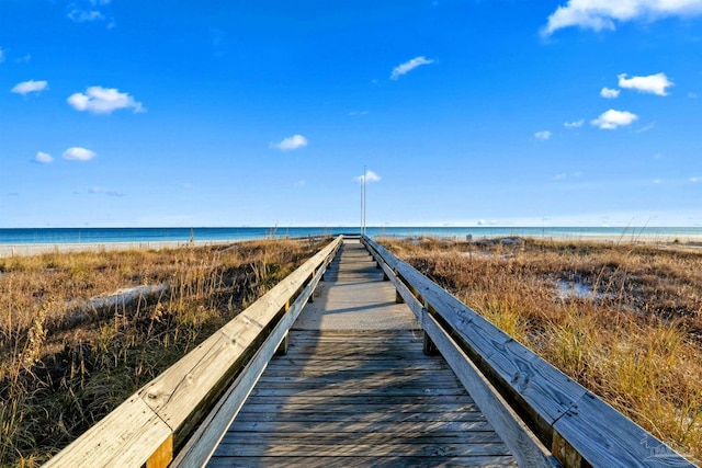 dock area with a water view and a beach view