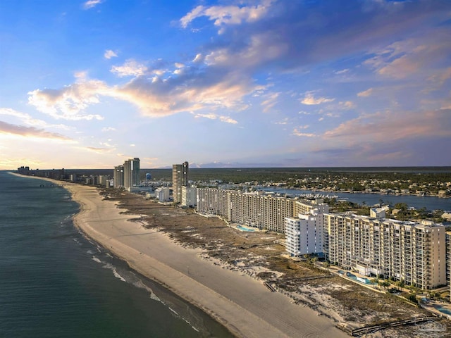 aerial view at dusk with a beach view and a water view