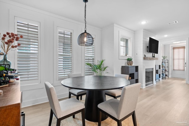 1550 W Romana St, Pensacola, FL 32502 - dining room with light wood-style flooring, a large fireplace, baseboards, crown molding, and recessed lighting