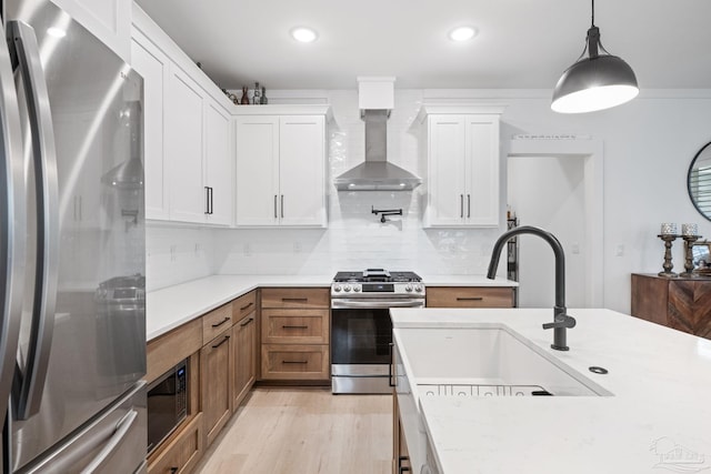 1550 W Romana St, Pensacola, FL 32502 - kitchen with stainless steel appliances, wall chimney range hood, light countertops, a sink, and tasteful backsplash