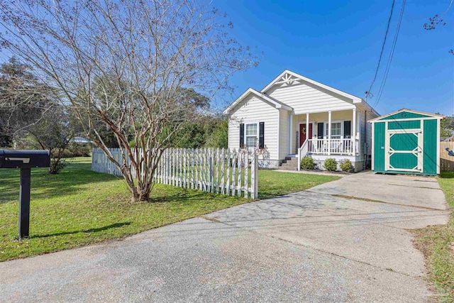 view of front of property featuring covered porch, a storage shed, an outdoor structure, fence, and a front yard