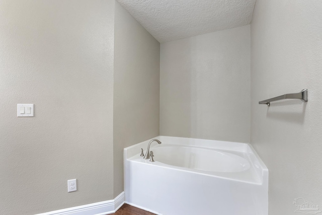 bathroom featuring a textured ceiling and a bathtub