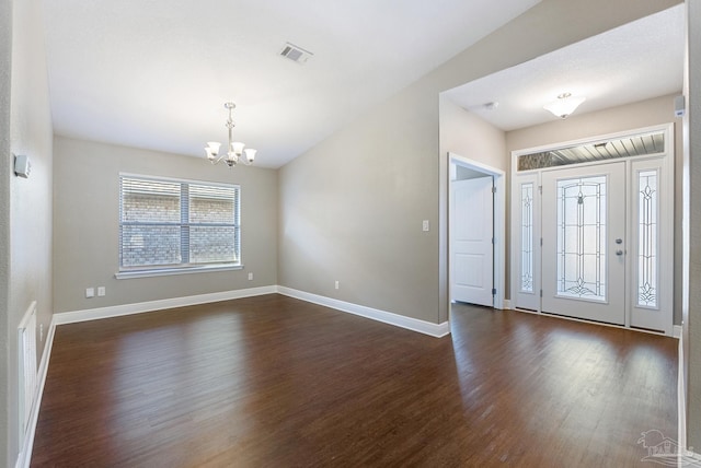 foyer with a chandelier, dark hardwood / wood-style floors, and lofted ceiling