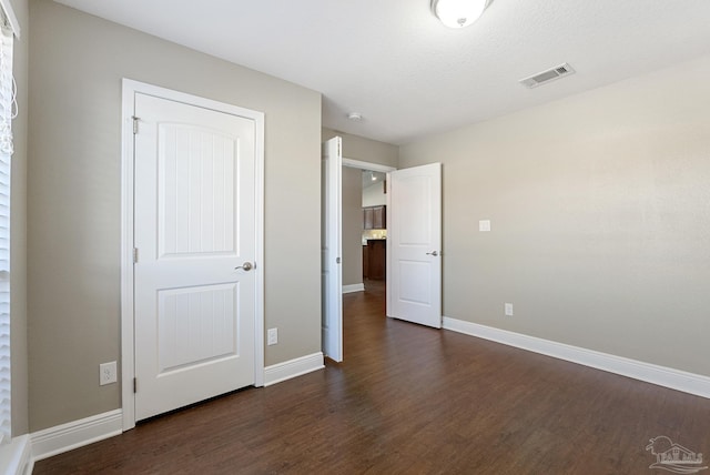 unfurnished bedroom featuring dark wood-type flooring