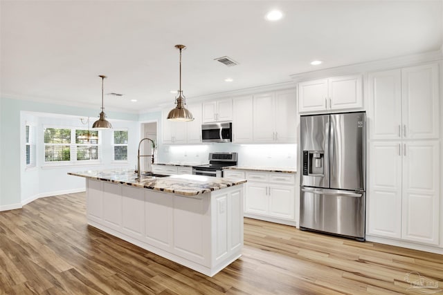 kitchen featuring white cabinets, appliances with stainless steel finishes, a center island with sink, and sink