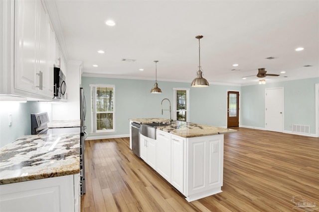 kitchen with a center island with sink, hanging light fixtures, appliances with stainless steel finishes, light hardwood / wood-style floors, and white cabinetry