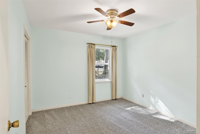 carpeted empty room featuring ceiling fan and a textured ceiling