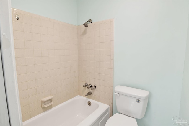 bathroom with toilet and tiled shower / bath