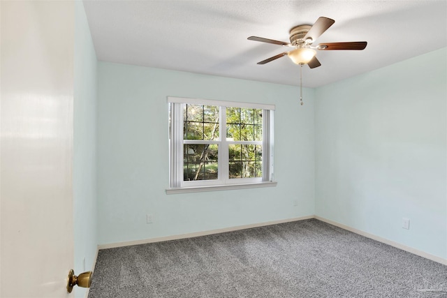 carpeted empty room featuring ceiling fan and a textured ceiling