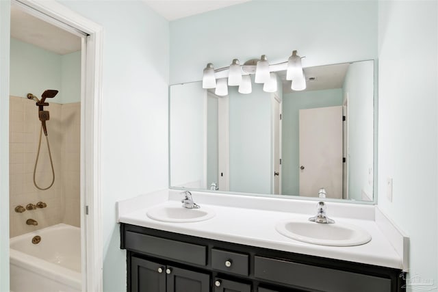 bathroom featuring tiled shower / bath combo and vanity